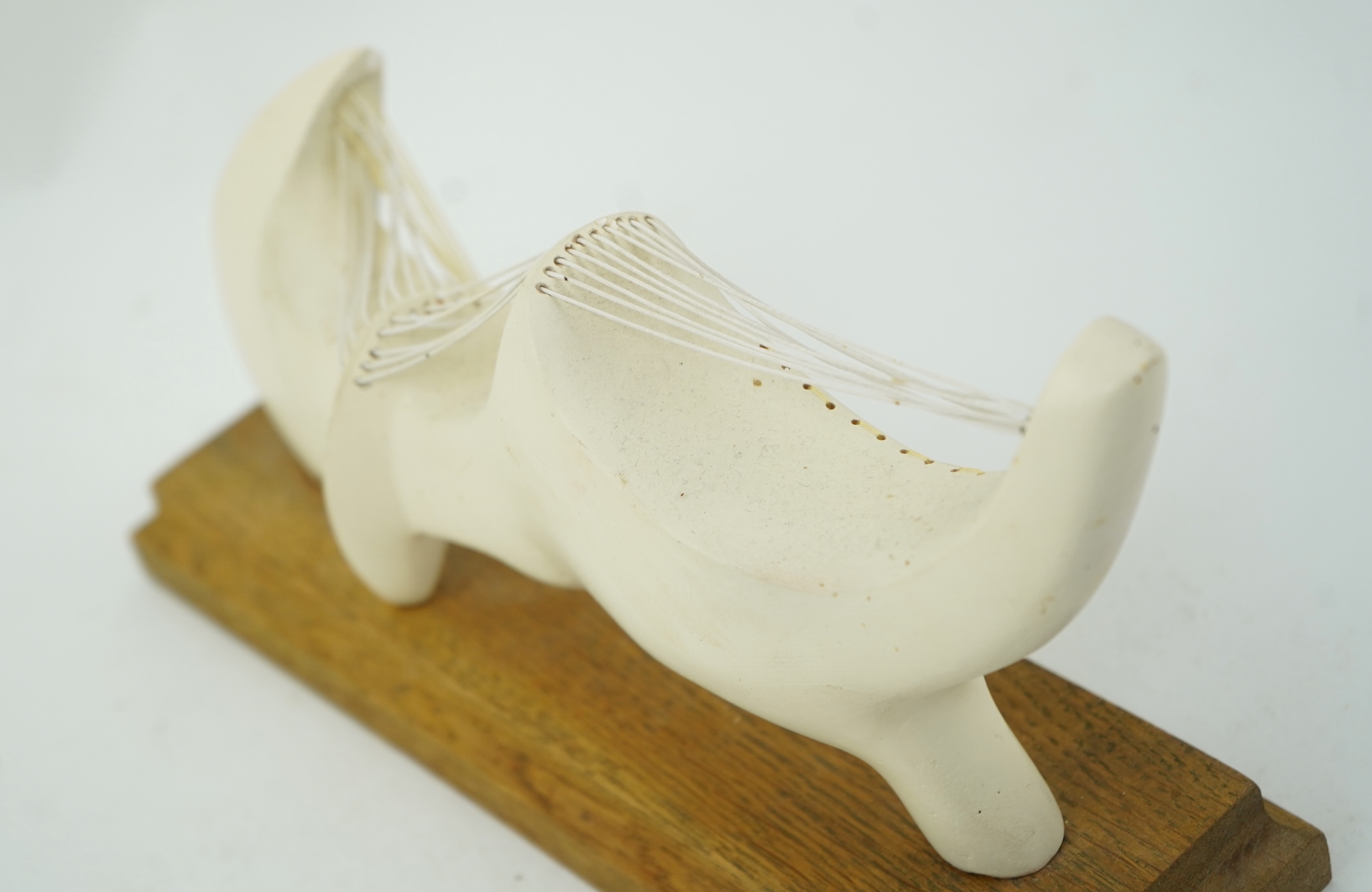Follower of Henry Moore (1898-1986) A modernist stringed plaster sculpture raised on an oak rectangular plinth base, 25cm wide